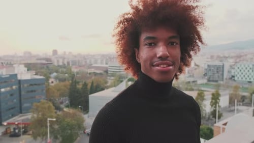 Close-up of young smiling guy posing at the camera modern city on the background