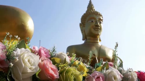 Flowers on a Background of a Large Golden Buddha in the Temple of Thailand Pattaya