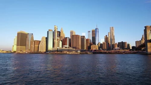 Aerial view low towards sunlit skyscrapers on the east side of lower Manhattan, sunrise in NY, USA