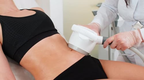 Cosmetologist Performs LPG Body Contouring Therapy on Woman Lying in Clinic During Slimming Session