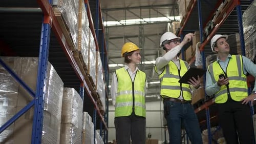 Blue collar workers are working at warehouse.