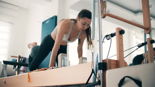 Woman Doing Pilates Exercise in Fitness Studio