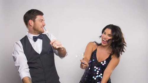 Dancing Couple Celebrating with Sparklers on White Background