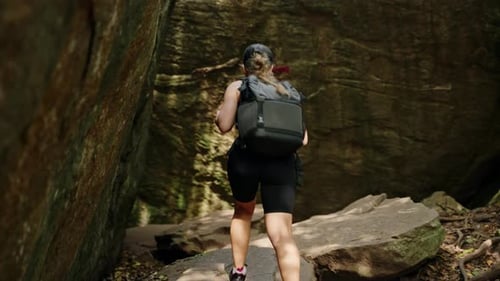Active Female Hiker Explores Narrow Gorge in Rocky Mountains Alone Touches Rough Stone Walls