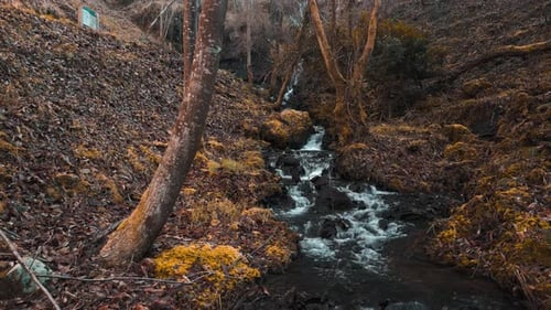 Ferveda de Rus - Water Flowing To The River From Waterfall. - aerial pullback shot