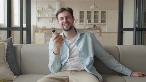 Man Relaxing on Couch with Remote Control