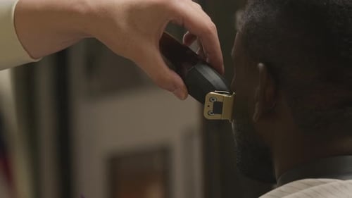 Barber Trimming Hair with Electric Razor Close Up