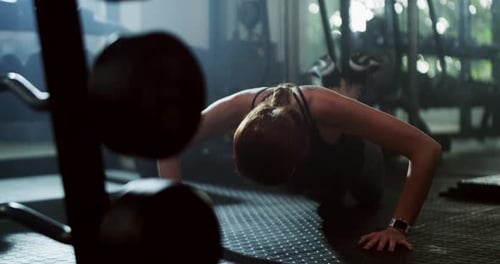 4k video footage of an attractive young sportswoman doing push ups while working out in a gym