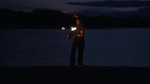 Woman Performs Fire Dance on Beach at Night