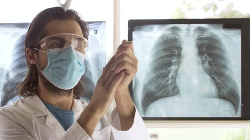 Doctor Applies Hand Sanitizer in Front of X-rays