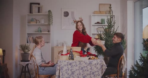 Woman Giving Christmas Presents to Friends