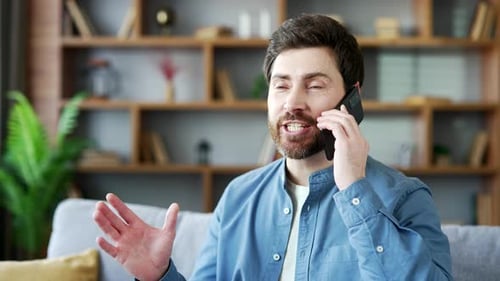 Smiling Man Chatting on Smartphone in Home