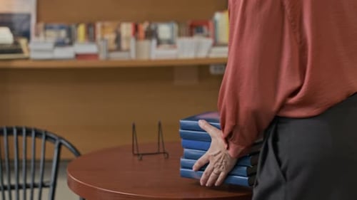Bookstore Worker Placing Book Copies on Display for Upcoming Author Session
