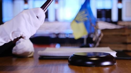 La sala del tribunal, el mazo y la bandera de Ucrania simbolizan la justicia fundamental respaldada por la ley