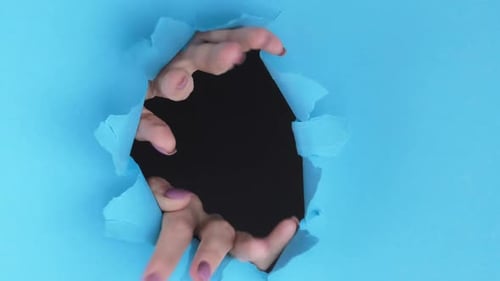 Hands Reaching Through Torn Blue Paper