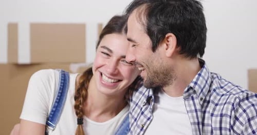 Portrait of a couple in love seated on the floor and they just bought a house and are moving. The