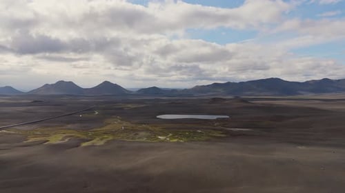 Aerial Shot Of Icelandic Highway In Green Valley With Rolling Hills
