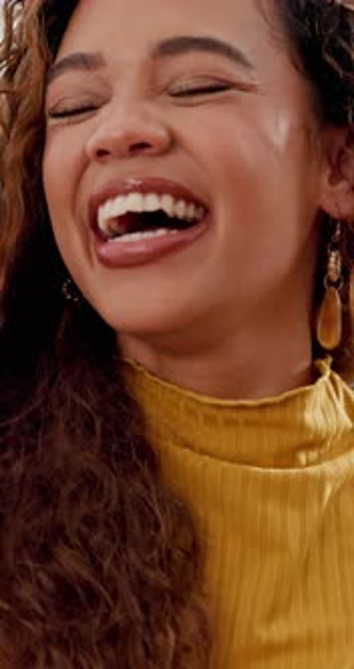 Woman Laughing While Using Mobile Phone Indoors