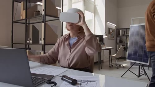Lap de temps d'une designer féminine avec un casque AR dessinant un prototype de batterie solaire