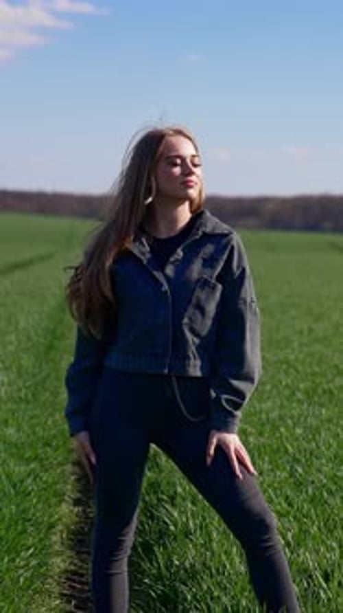 Woman Poses in Grassy Field on a Sunny Day