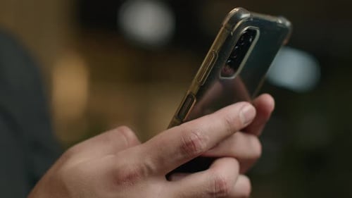 Adult Holding Phone in Urban Environment