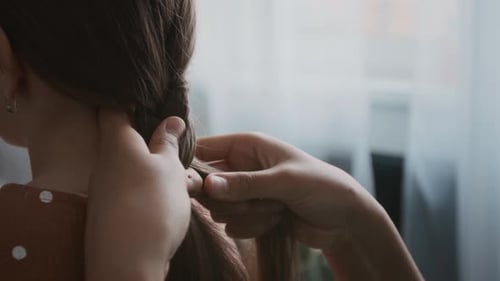 Girl Braiding Little Sisters Hair