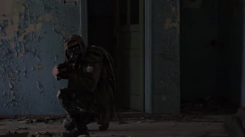 Ein Soldat in einer Gasmaske mit einer Waffe im Gebäude