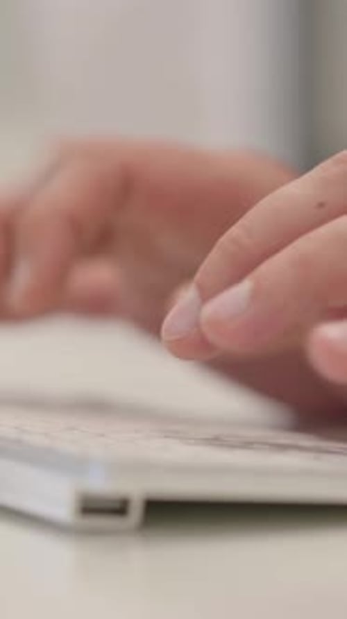 Hands Typing on a White Computer Keyboard