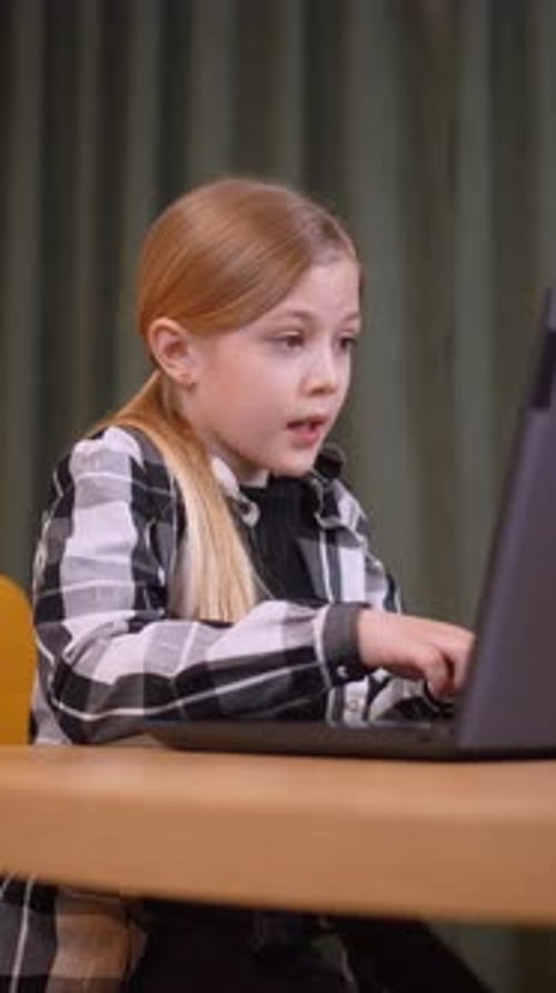Niña programando en una computadora portátil: código de aprendizaje concentrado para estudiantes de primaria