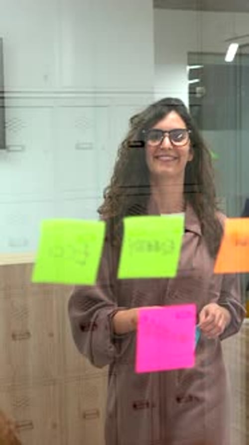 Diverse Business Team Brainstorming with Sticky Notes on Glass Wall