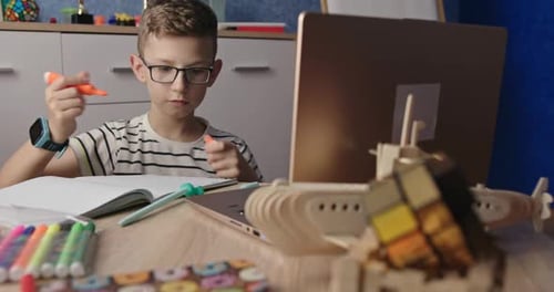 Boy Doing Homework in Front of Laptop