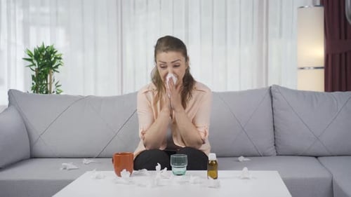 Woman covering mouth and nose while sneezing.
