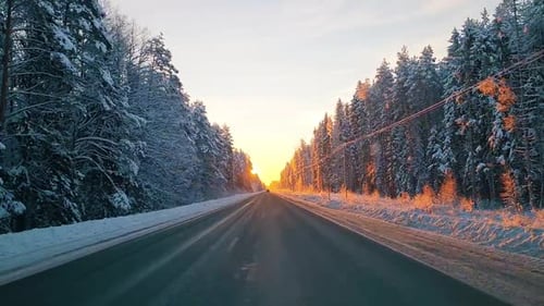 Snow covered asphalt roads. Snow on asphalt. View from the car on the winter road