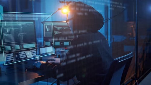 Hacker Working on Multiple Computer Screens at Night