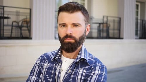 Attractive Thoughtful Blueeyed Bearded Man in Trendy Checkered Shirt Brutally Looks Straight to
