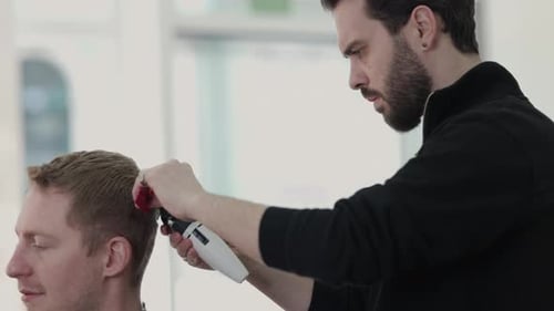 Man Gets Haircut From Barber in Modern Salon