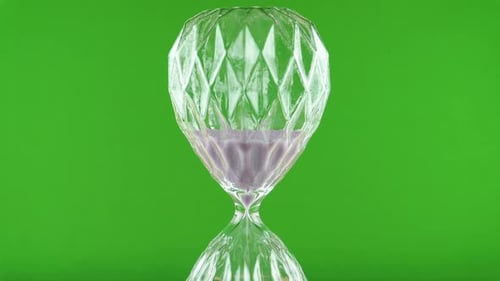 Rotating Purple Hourglass On A Green Background.