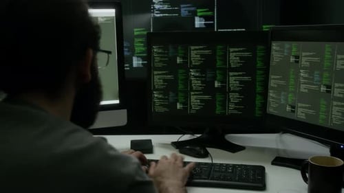 Programmer Typing on Computer Keyboard, Working on Code in Dimly Lit workspace