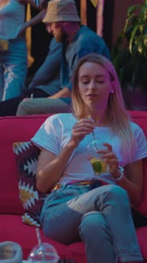 Woman Relaxing with Drink at Outdoor Party