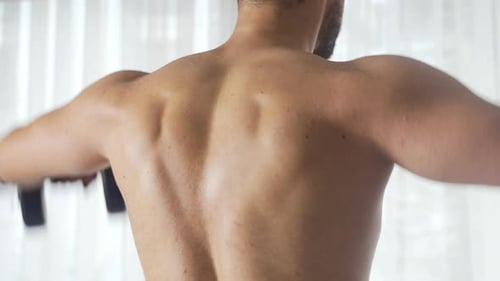 Homem musculoso fazendo exercícios.