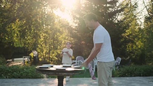 Father and Son are Preparing a Table for Dinner on the Street Near the House