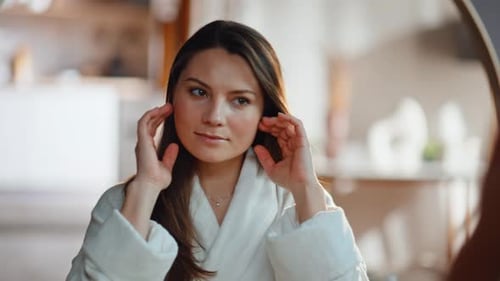 Woman in Robe Doing Skincare in Mirror