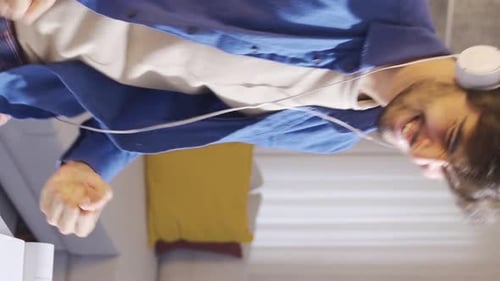 Enthusiastic Young Adult Dances to Music at Home