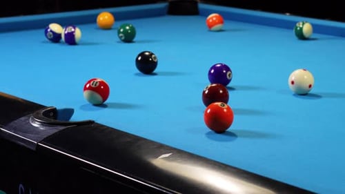 Playing a game of billiards pool hitting cue ball with cue stick.