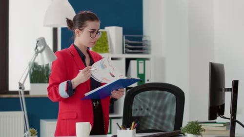 Stylish Woman Reviews Documents in Modern Office
