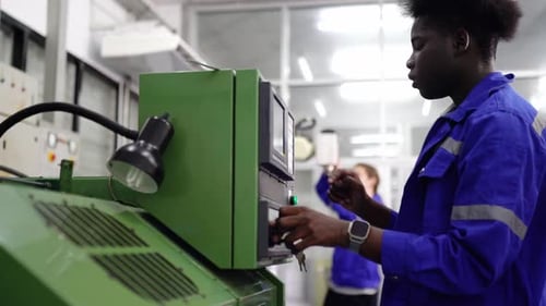 Industriearbeiter, der Daten in die CNC-Maschine im Werk eingibt