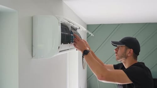 Man Changing Air Conditioner Filter in Home