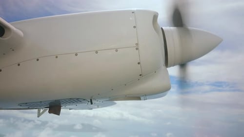 Charter engine from window view. Airplane propeller turbine flying through clouds. Jet engine soarin