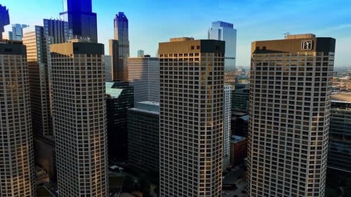 Flying at the windows of four similar high-rise building in the panorama of big city.