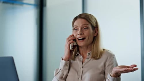 Surprised Woman Wondering Smartphone at Workplace Close Up. Smiling Entrepreneur Talking Emotionally